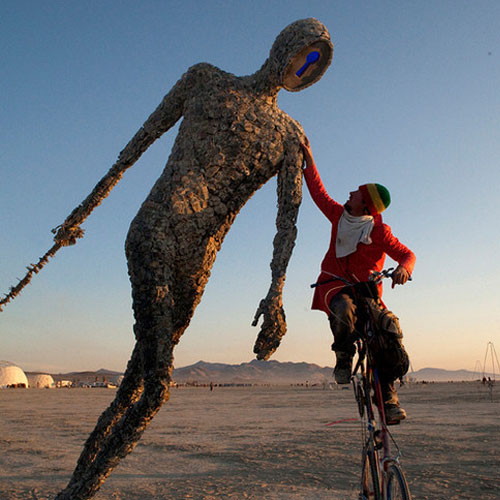 man on bike with giant sculpture